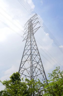 Mavi gökyüzü arka planına sahip yüksek voltajlı elektrik hatları kulesi