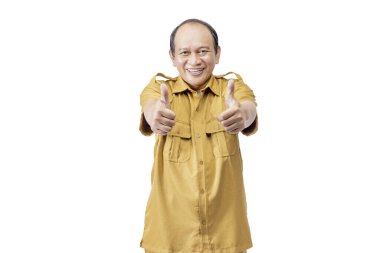 Beyaz bir arkaplan üzerinde izole edilmiş, baş parmaklı bir jest ile duran devlet memuru. Pegawai Negeri Sipil (PNS)
