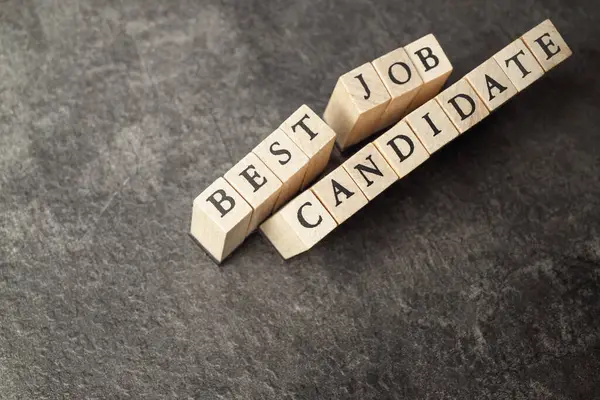 Wooden cube with BEST JOB CANDIDATE letter. Human resources management concept