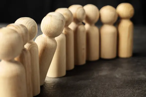 Stand out wooden figures from the row of wooden figures. Human resources management concept