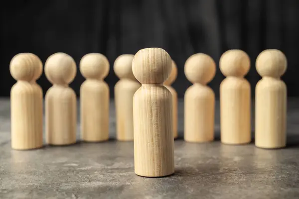 Stand out wooden figures from the row of wooden figures. Human resources management concept