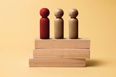 Red wooden figures stand out from the crowd of wooden figures. Leadership concept