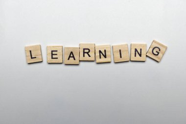 A row of wooden cubes with learning letters on a white background. Learning concept