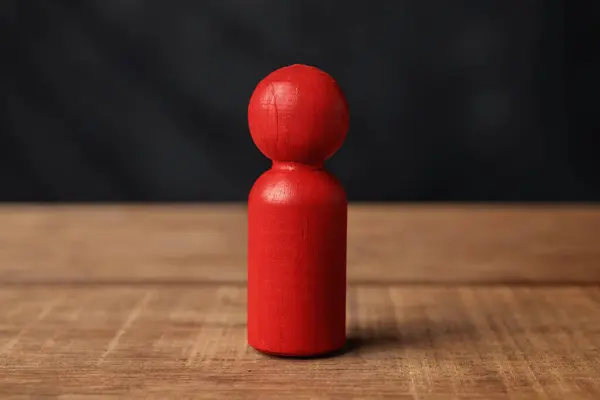 Closeup view of a red wooden figure on a wooden table