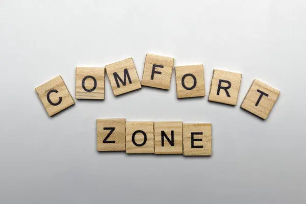 A row of wooden cubes with comfort zone letters on a white background. Business, psychology, and comfort zone concept