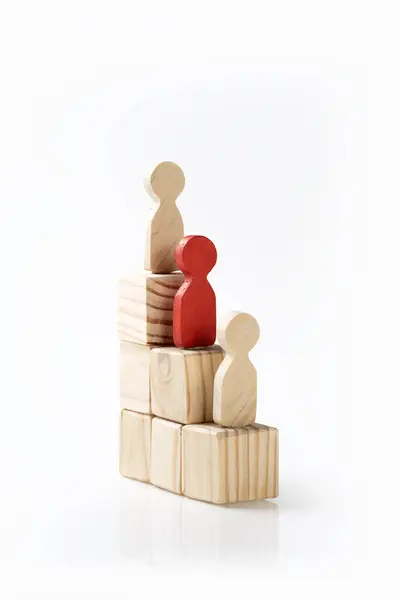 Wooden figures standing on wooden cube stairs. Human resources management concept