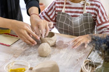 Islak çamurdan porselen bardak yapan çocukların yakın görüntüsü. Çömlek sanatı kil kavramı