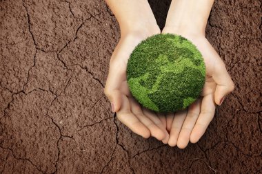 İnsan eli kuraklık tarlasının üzerindeki verimli toprakları gösteriyor. Çevre ve iklim değişikliği kavramı