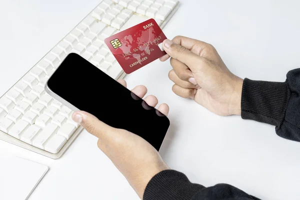 People hand holding credit cards and mobile phones with empty screens for mobile payment, banking, or online shopping. Empty mobile phone screen for copy space. Online payment concept