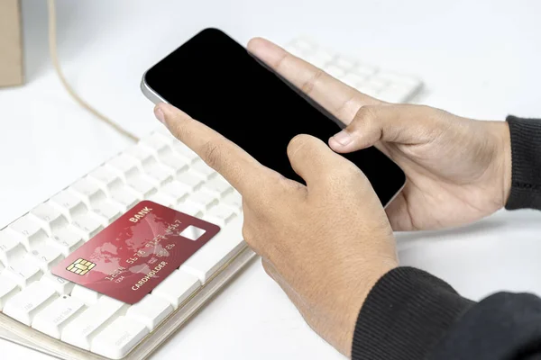 People hand holding mobile phones with empty screens and credit cards for mobile payment, banking, or online shopping. Empty mobile phone screen for copy space. Online payment concept