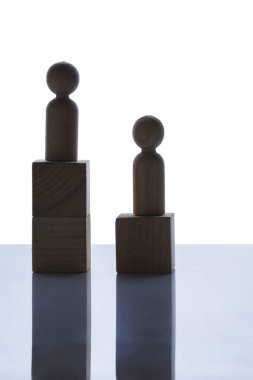 Tahta bir kübün üzerinde duran tahta figürlerin beyaz arka plandaki yakın görüntüsü. İnsan kaynakları yönetim kavramı