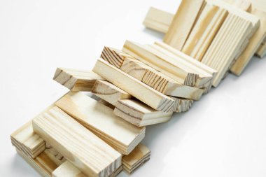 Ahşap bloğun kulesinin beyaz arka plana düşüşünün yakın görüntüsü. Jenga Kulesi