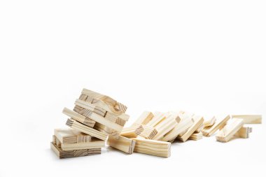 Ahşap bloğun kulesinin beyaz arka plana düşüşünün yakın görüntüsü. Jenga Kulesi