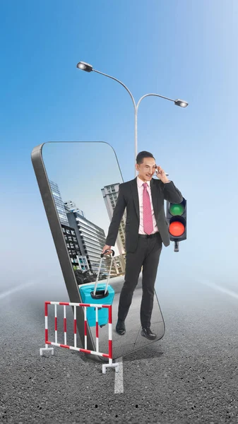 A businessman on a phone call walking while carrying suitcase on the street with a city view on the mobile phone screen. Traveling concept