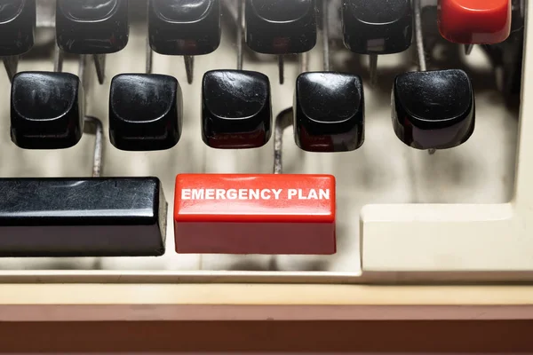 Text of \'Emergency plan\' on a vintage typewriter button. Emergency action plan concept