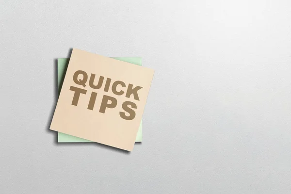 Stack of note paper with 'Quick tips' text on a white background. Tips and advice concept