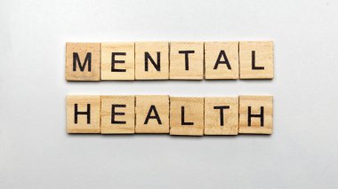 Akıl sağlığı metni olan küçük tahta küplerin sırası renkli bir arka planda. Ruh sağlığı konsepti