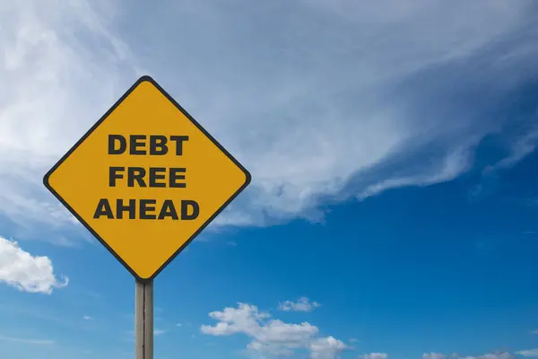 Image of yellow road sign with debt free ahead written on it with blue sky background. Concept of financial bankruptcy from getting rid of debts. Business financial problems debt.