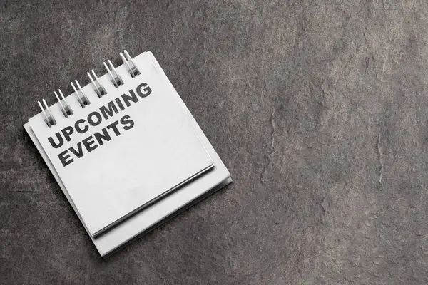 Note with \'upcoming events\' text on a black background. Event planning concept
