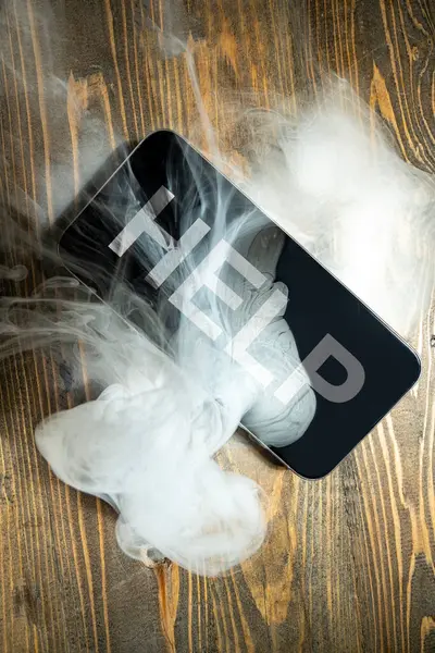 Close up smartphone with smokes and words Help on a wooden desk. Damage equipment.