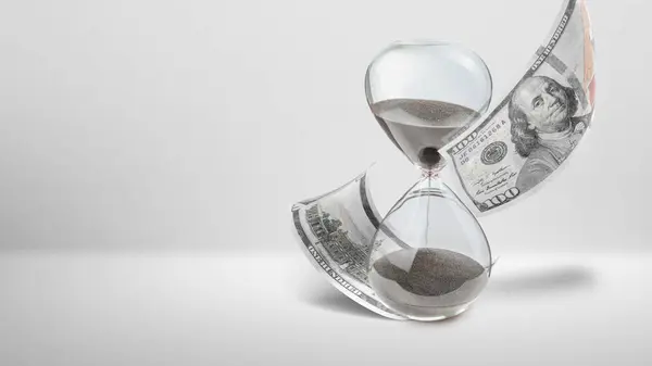 Close up hourglass and money isolated over white background. Time is money concept.