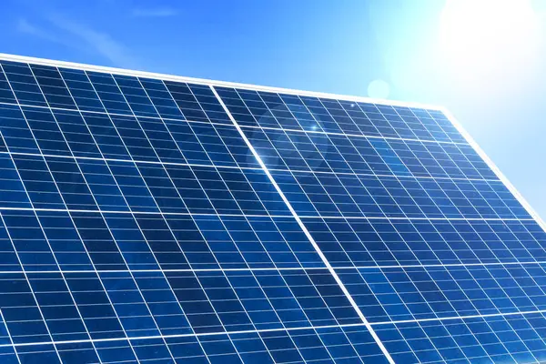 Image of solar panel with sunlight on blue sky background. Clean source power. Alternative energy ecological concept.