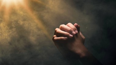 Hıristiyan adam parlak bir arka plan için ellerini kaldırarak dua ediyor. Hıristiyan konsepti