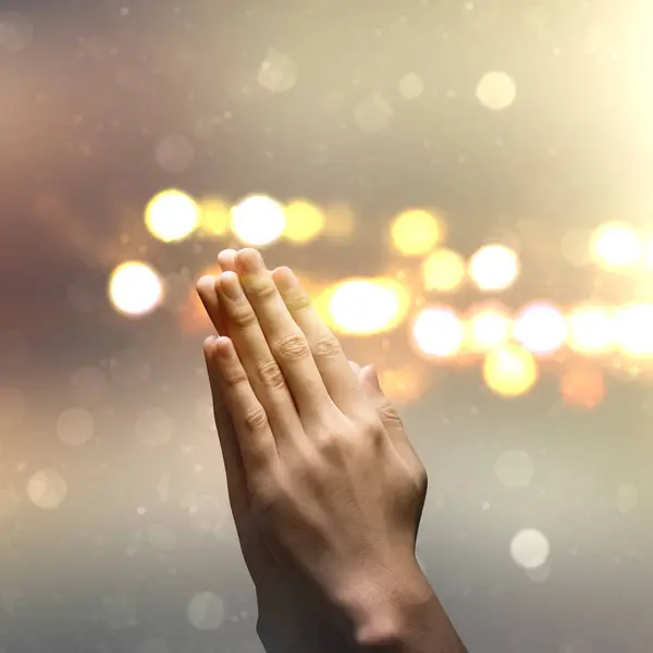 Close up man hand pray with defocused light background. Concept of hope, faith, christianity, religion, church