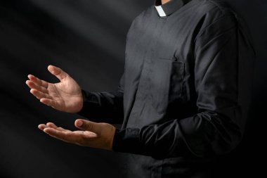 Siyah arka planda vaaz veren bir papazın portresi. Hıristiyan konsepti