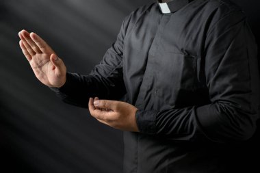 Siyah arka planda vaaz veren bir papazın portresi. Hıristiyan konsepti