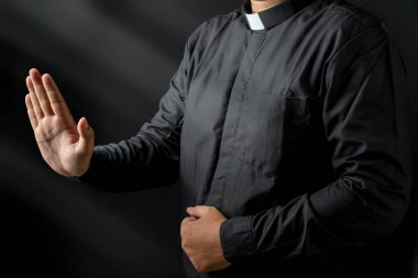 Siyah arka planda vaaz veren bir papazın portresi. Hıristiyan konsepti