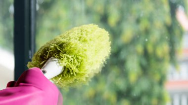 İnsan eli koruyucu eldivende, pencereyi silmek için toz bezi kullanıyor. Temizlik kavramı