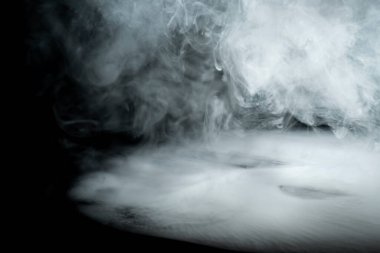 Karanlık arka planda girdap gibi beyaz duman. Soyut arkaplan