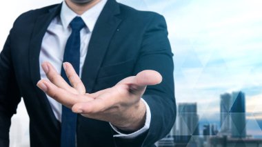 Kentin arka planında, avuç içi açık poz veren kendine güvenen bir iş adamının portresi