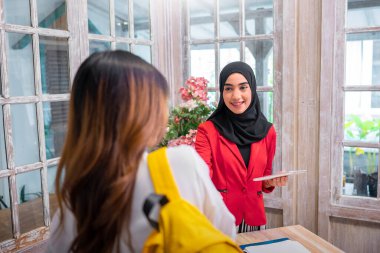 Tanışma için kadın bir müşteriyle kadın müslüman el sıkışması resmi. Yaratıcı başlangıç ekibi yeni strateji için beyin fırtınası yapıyor.