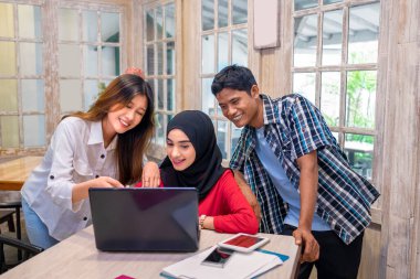 Kafedeki bir toplantıda iş projesini tartışan çok ırklı iş arkadaşlarının portresi