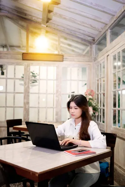 一个女商人在咖啡店工作时使用笔记本电脑的肖像 图库图片