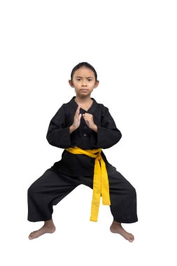 Focused young child demonstrates a karate stance, wearing a black gi with a yellow belt, symbolizing an intermediate level, isolated on a white background, showcasing discipline and strength clipart