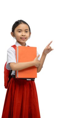 Elinde bir kitapla duran sırt çantasıyla Asyalı bir ilkokul öğrencisinin portresi beyaz bir arkaplanda izole edilmiş bir fotokopi alanını işaret ediyor.