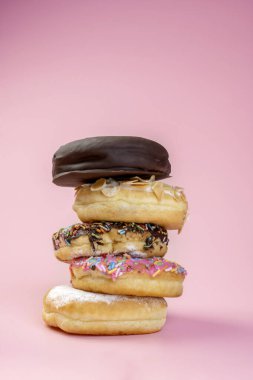 Renkli arka planda farklı süslerle çeşitli lezzetli çörekler serpiştirilmiş.