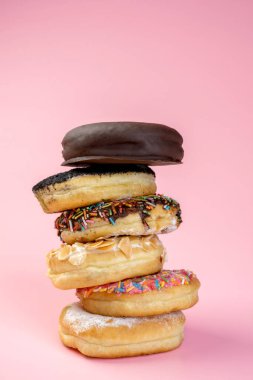 Renkli arka planda farklı süslerle çeşitli lezzetli çörekler serpiştirilmiş.