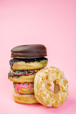 Renkli arka planda farklı süslerle çeşitli lezzetli çörekler serpiştirilmiş.