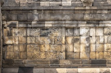 Candi Mendut, Magelang, Endonezya - 22 Mayıs 2024. Kahverengi ve gri tuğlalardan oluşan bir duvar. Duvar eski ve kırsal bir havası var.