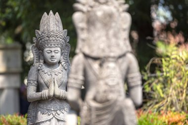 Candi Mendut, Magelang, Endonezya - 22 Mayıs 2024. Buda 'nın taş heykeli parktaki ağaçlarla çevrili taş bir heykel üzerinde duruyor.