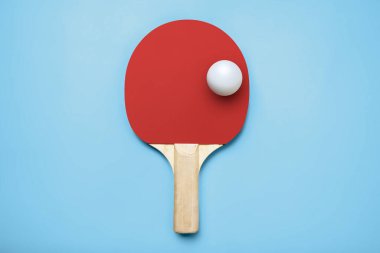 Masa tenisi oynamak için renkli bir arka planda pinpon raketi.