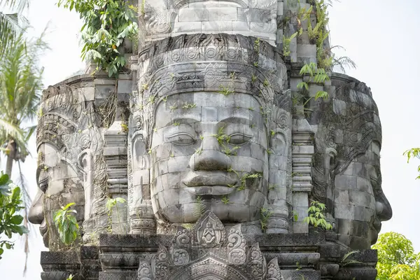 Candi Mendut, Magelang, Endonezya - 22 Mayıs 2024. Kadim Buda heykeli mavi gökyüzü arkaplanlı taş binanın üzerinde.