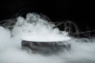 Yuvarlak platform, siyah zemin üzerinde dalgalanan beyaz dumandan ortaya çıkar. Yaratıcı yerleştirme için geniş alanı olan ürünleri veya konuları sergilemek için mükemmel gizemli bir atmosfer yaratır.