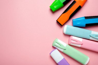 Pembe arka planda çeşitli renklerde işaretler var. İşaretler üst üste binen bir daire şeklinde dizilmiş. Renkler arasında yeşil, mavi, pembe ve beyaz vardır.