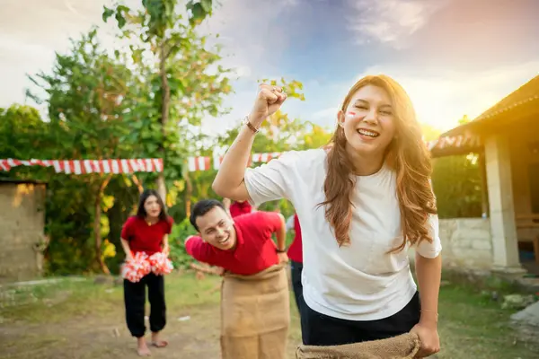 stock image A group of people are playing a game of sack race. Scene is lighthearted and fun, as the group of people are laughing and enjoying themselves. Indonesian independence day concept