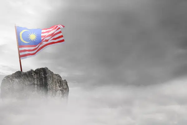 stock image A Malaysia flag with a yellow star and red stripes is waving in the wind. The sky is cloudy and the sun is not visible